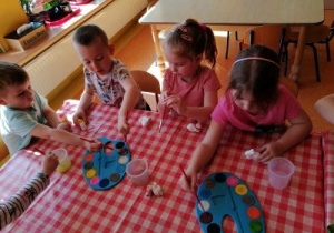 Dzieci wykonują prace plastyczną.
