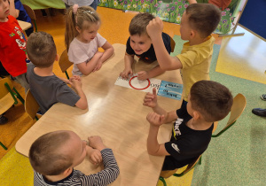 Dzieci z grupy Motylki oraz Pszczółki rozwiązują zadania dotyczące ekologii.