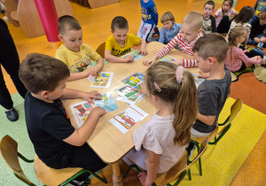 Dzieci z grupy Motylki oraz Pszczółki rozwiązują zadania dotyczące ekologii.