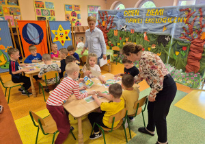 Dzieci z grupy Motylki oraz Pszczółki rozwiązują zadania dotyczące ekologii.