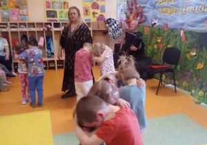Dzieci uczestniczą w koncercie muzycznym, wykonują taniec.