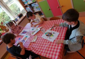 Dzieci wykonują pracę plastyczną o kosmosie.