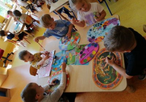 Dzieci wykonują pracę plastyczną o kosmosie.