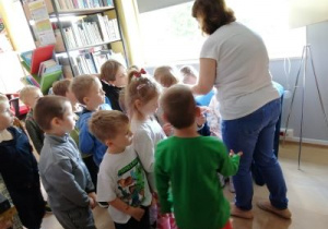 Dzieci z grupy Biedronek wręczają upominek pani z biblioteki.