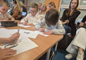 Przedszkolaki rozwiązujący matematyczne zadania.