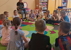 Dzieci słuchają bajki czytanej przez mamę Szymona.