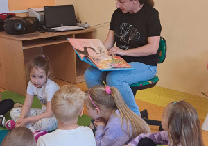 Dzieci słuchają bajki czytanej przez mamę Szymona.