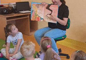 Dzieci słuchają bajki czytanej przez mamę Szymona.