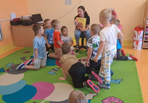 Dzieci słuchają bajki czytanej przez mamę Szymona.