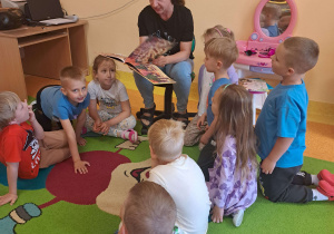 Dzieci słuchają bajki czytanej przez mamę Szymona.