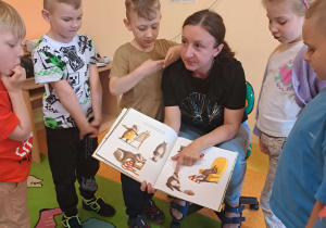 Dzieci słuchają bajki czytanej przez mamę Szymona.