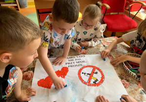 Dzieci wykonują plakaty nt dnia bez tytoniu.