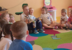 Dzieci słuchają bajki czytanej przez rodzica.