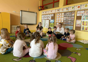 Dzieci słuchają bajki czytanej przez rodzica.