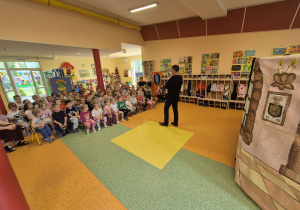Dzieci oglądają teatrzyk w wykonaniu aktorów.