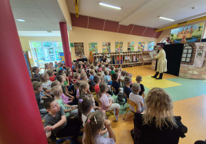 Dzieci oglądają teatrzyk w wykonaniu aktorów.