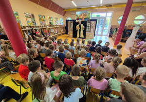 Dzieci oglądają teatrzyk w wykonaniu aktorów.