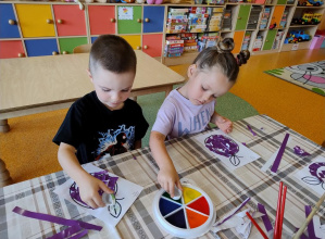 Dzieci stemplują farbami liście.