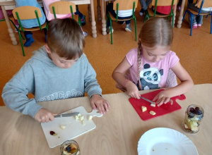 Dzieci kroją owoce.