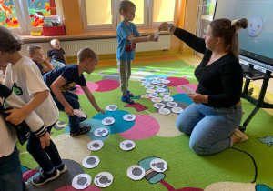 Dzieci dobierają cienie do kolorowych obrazków.