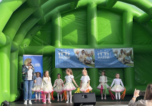Dzieci tańczą na scenie.