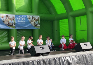 Dzieci tańczą na scenie.