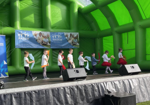Dzieci tańczą na scenie.