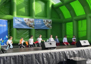 Dzieci tańczą na scenie.