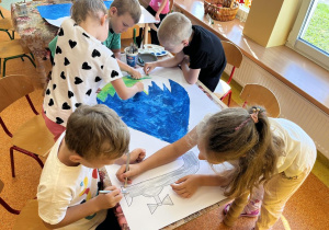 Dzieci malują farbami i rysują kredkami.