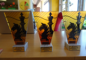 Na stole stoją puchary dla zwycięzców turnieju szachowego