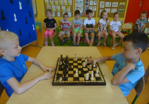 Franek i Kacper grają w szachy, siedzą na przeciwko siebie