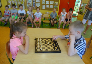 Kaja i Gabryś grają w szachy, siedzą na przeciwko siebie