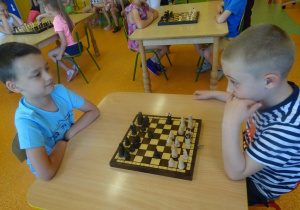 Kacper i Gabryś siedzą na przeciwko siebie i grają w szachy