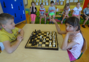 Kuba i Hania siedzą na przeciwko siebie i grają w szachy