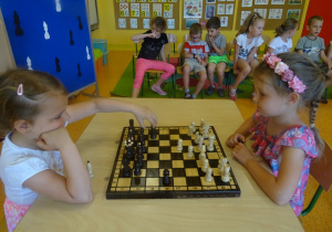 Marysia i Natalka siedzą na przeciwko siebie i grają w szachy