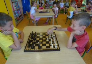 Filip i Kuba siedzą na przeciwko siebie i grają w szachy