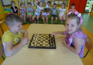 Natalka i Kuba siedzą na przeciwko siebie i grają w szachy