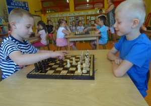Gabryś i Franek siedzą na przeciwko siebie i grają w szachy