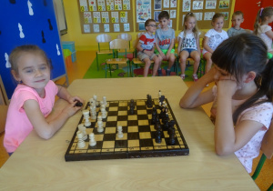 Kaja i Hania siedzą na przeciwko siebie i grają w szachy