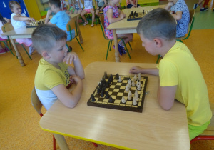 Filip i Kuba siedzą na przeciwko siebie i grają w szachy