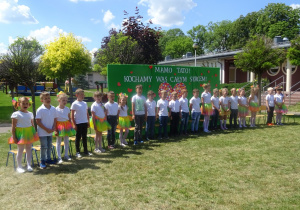 Dzieci stoją na tle zielonej tablicy , mówią wiersz