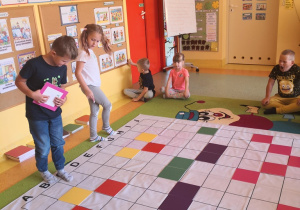 Dzieci układają kolorowe tabliczki wg kodu na macie