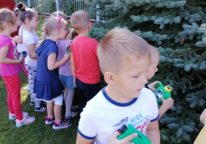 Dzieci oglądają przez lupę owady.