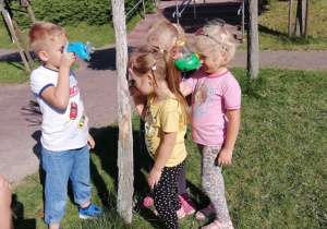 Dzieci oglądają przez lupę owady.