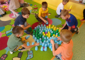 Dzieci układają kropkę z kubeczków w małych zespołach.