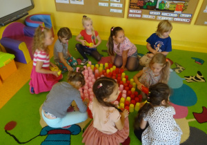 Dzieci układają kropkę z kubeczków w małych zespołach.