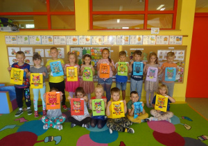 Dzieci prezentują swoje prace, sowę wyklejoną kropkami z plasteliny.