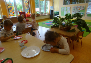 Dzieci oglądają kryształki cukru przez lupę, mikroskop.
