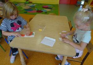 Dwójka dzieci układa obrazki z części.