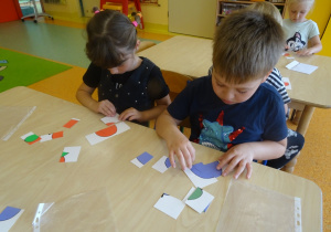 Dwójka dzieci układa obrazki z części.
